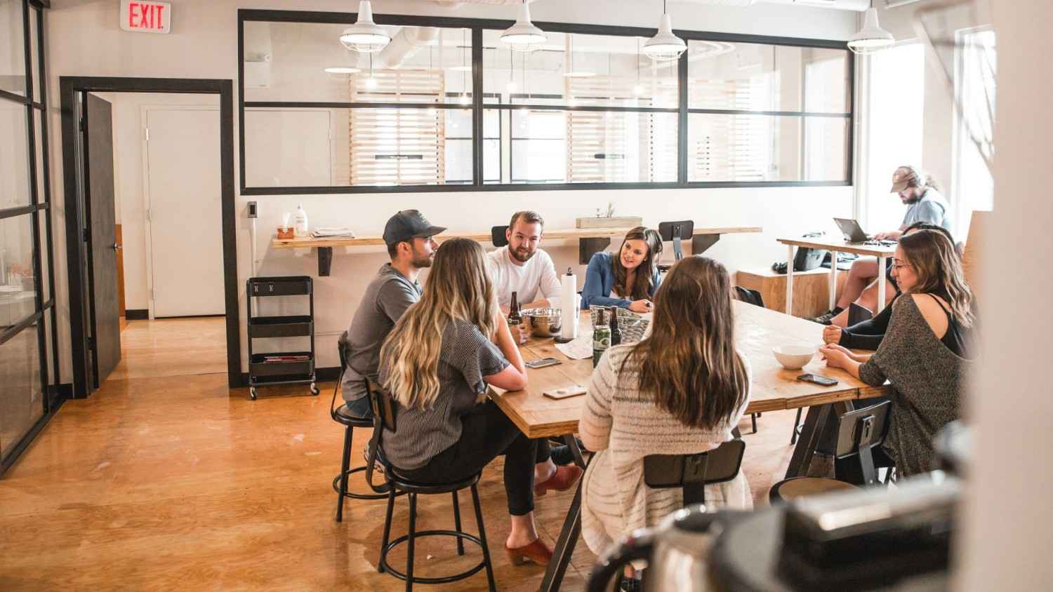 Des personnes discutent en étant assises à côté d'une table.
